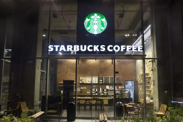 A Starbucks store viewed from the front at night with its lights and signs turned on.