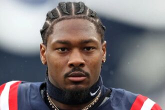 The well-known wide receiver wearing the New England Patriots uniform with a very serious expression before the start of a game.