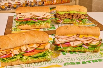 Four delicious sandwiches placed on a green table.