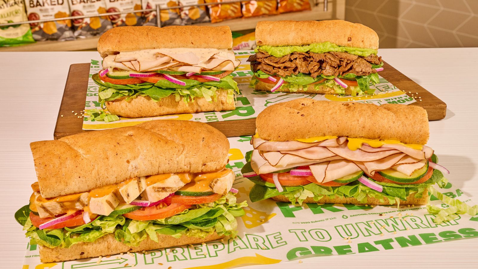 Four delicious sandwiches placed on a green table.