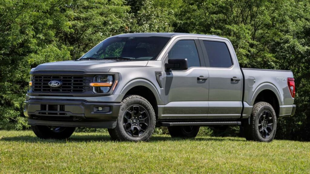 A hybrid Ford pickup truck parked on grass for a photoshoot.