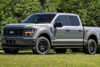 A hybrid Ford pickup truck parked on grass for a photoshoot.