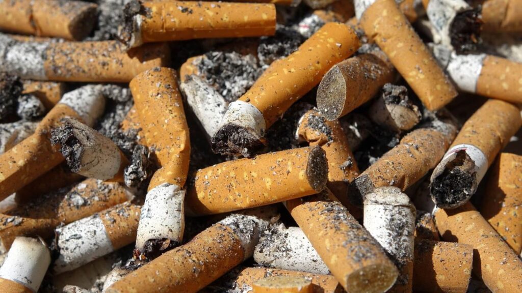 A large pile of cigarettes stacked and burned on a table.