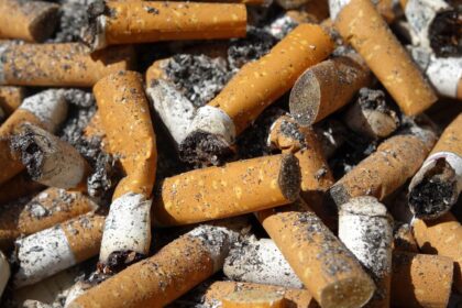 A large pile of cigarettes stacked and burned on a table.