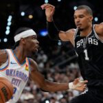 The French superstar Victor Wembanyama fiercely defending Shai Gilgeous-Alexander as he drives to the basket