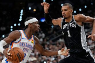 The French superstar Victor Wembanyama fiercely defending Shai Gilgeous-Alexander as he drives to the basket