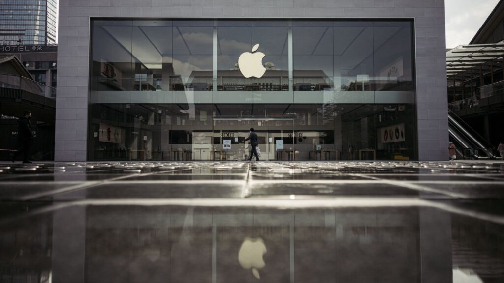 One of Apple’s stores on a rainy day, with its iconic apple logo standing out among other shops