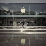 One of Apple’s stores on a rainy day, with its iconic apple logo standing out among other shops