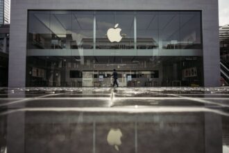 One of Apple’s stores on a rainy day, with its iconic apple logo standing out among other shops