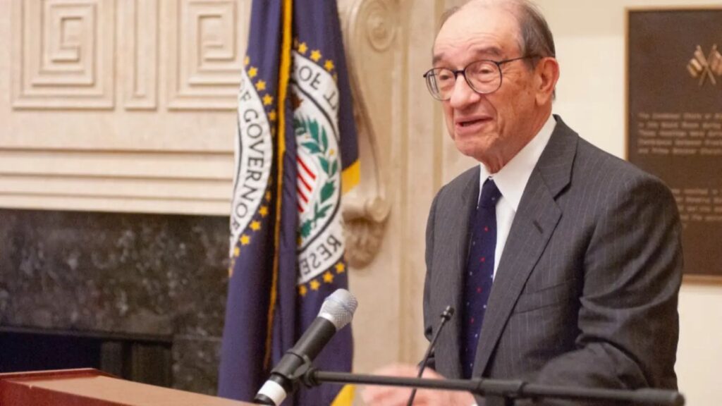 Alan Greenspan dies at 100: The legacy of the “Maestro of the Federal Reserve” under scrutiny Alan standing and speaking from a podium, wearing an elegant and impressive suit