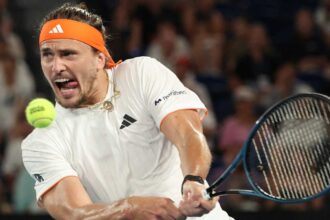The renowned tennis player about to hit the ball while sticking his tongue out