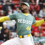 The Cuban pitcher throwing during a game while wearing the Boston team's green uniform