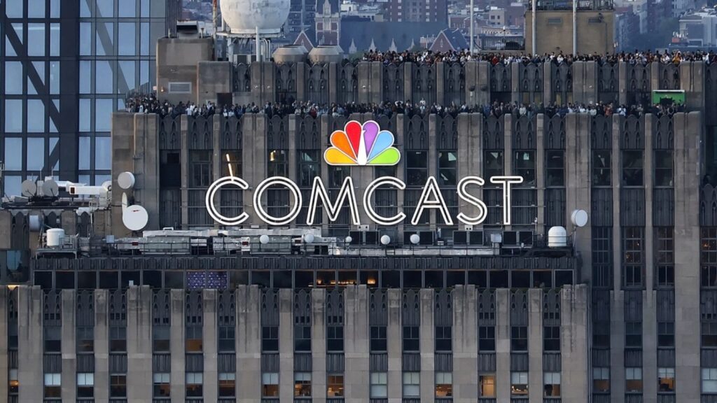 The COMCAST company name displayed at the top of a tall building in its distinctive multicolored branding