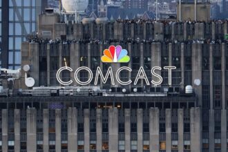 The COMCAST company name displayed at the top of a tall building in its distinctive multicolored branding