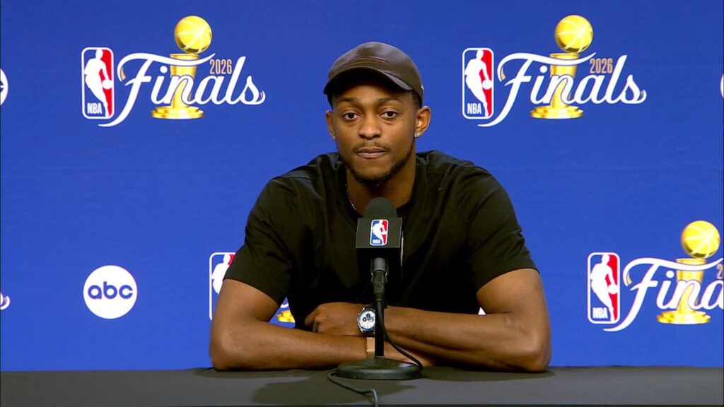 Fox sitting at a table after the game, speaking during a press conference