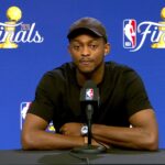 Fox sitting at a table after the game, speaking during a press conference