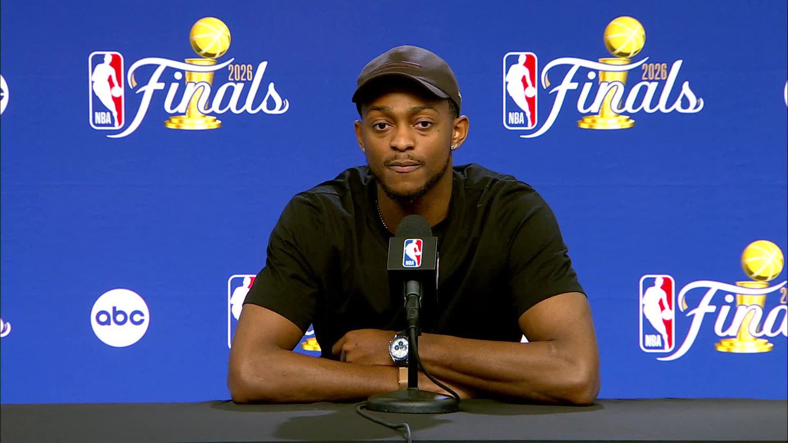 Fox sitting at a table after the game, speaking during a press conference