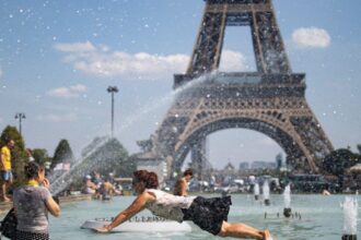 Several people swimming in a pool in front of the Eiffel Tower due to the extreme heat