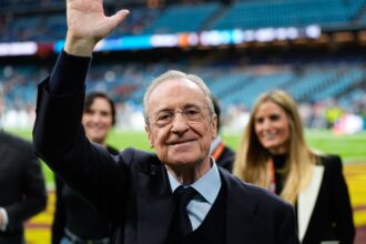 Florentino waving to Real Madrid fans from the pitch after a victory