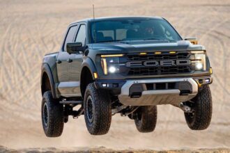 A rugged Ford pickup truck soaring through the air after hitting a ramp.