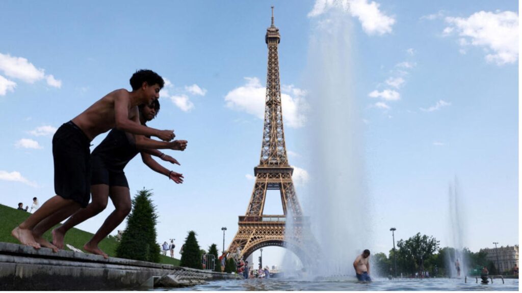 Several children jumping into a swimming pool in front of the Eiffel Tower