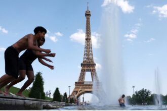 Several children jumping into a swimming pool in front of the Eiffel Tower