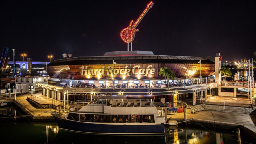 A panoramic view of the Hard Rock Cafe at night, with its eye-catching lights illuminated