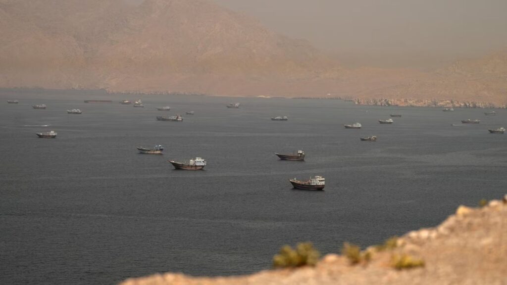 A panoramic view of the Strait of Hormuz, where several Iranian naval vessels can be seen patrolling and protecting the coastline