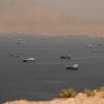 A panoramic view of the Strait of Hormuz, where several Iranian naval vessels can be seen patrolling and protecting the coastline