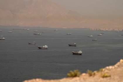 A panoramic view of the Strait of Hormuz, where several Iranian naval vessels can be seen patrolling and protecting the coastline