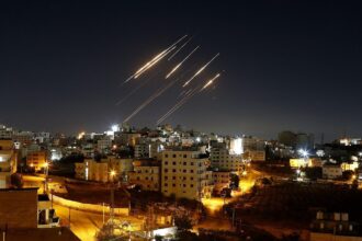 Several missiles being launched from their launchers toward a city