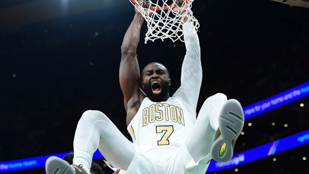 The American player making an incredible dunk while wearing his white and gold uniform