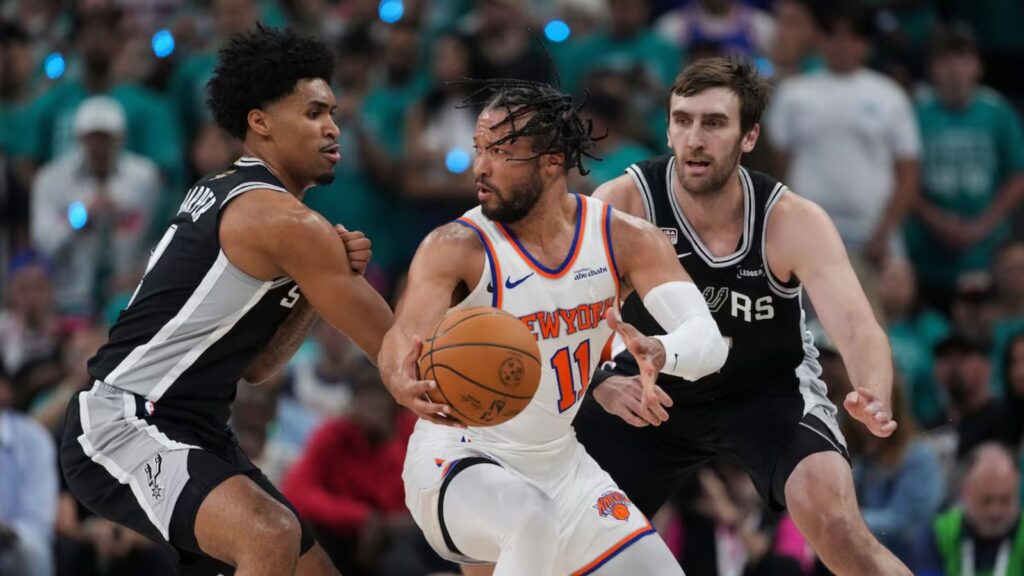 Jalen trying to dribble past two Spurs players in order to score