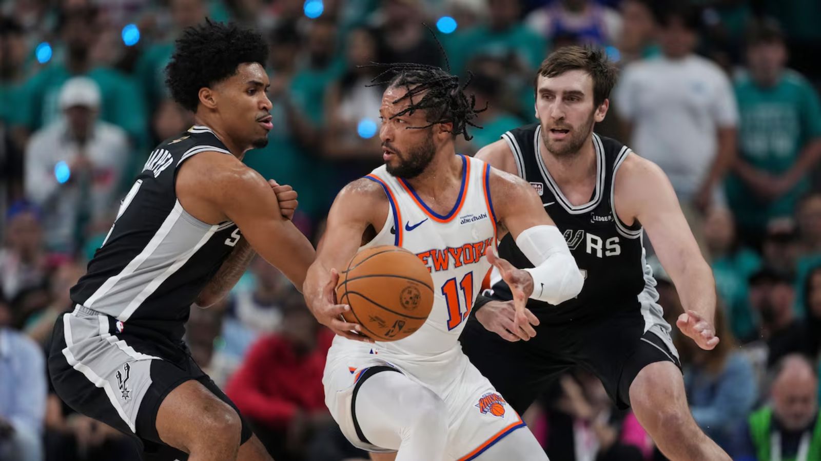 Jalen trying to dribble past two Spurs players in order to score