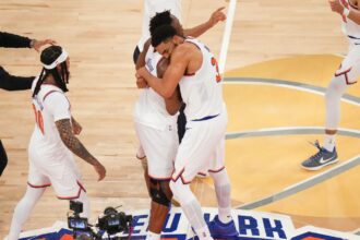 Several Knicks players embracing each other while celebrating their victory in Game 4