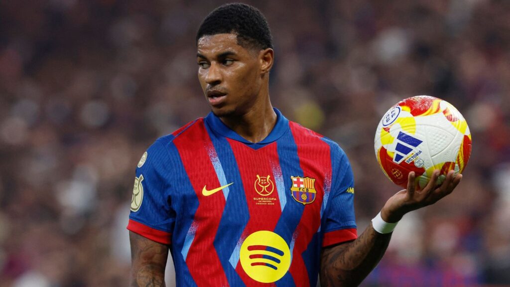 The English player holding the ball in one hand while looking toward the fans in the stadium