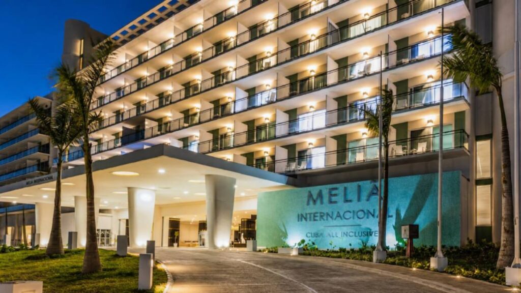 A panoramic photo of the hotel entrance with its logo and name displayed outside the building