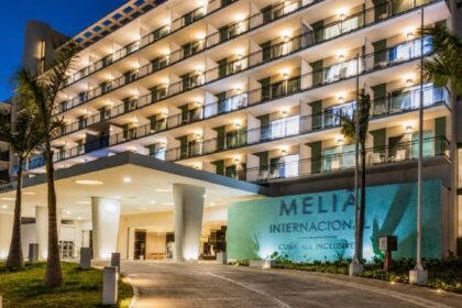 A panoramic photo of the hotel entrance with its logo and name displayed outside the building