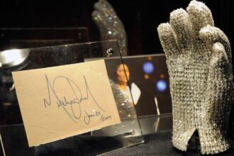 Michael Jackson’s glove displayed vertically with the King of Pop’s original signature beside it