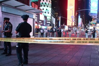 Several police officers cordoning off an area of Times Square following a firearm-related incident