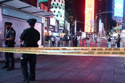 Several police officers cordoning off an area of Times Square following a firearm-related incident