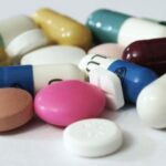 A white background with several pills scattered around, some stacked on top of each other
