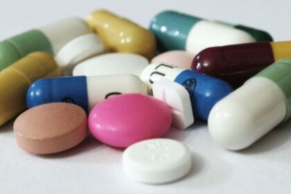 A white background with several pills scattered around, some stacked on top of each other