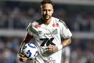 Neymar wearing the Santos jersey while running during a match