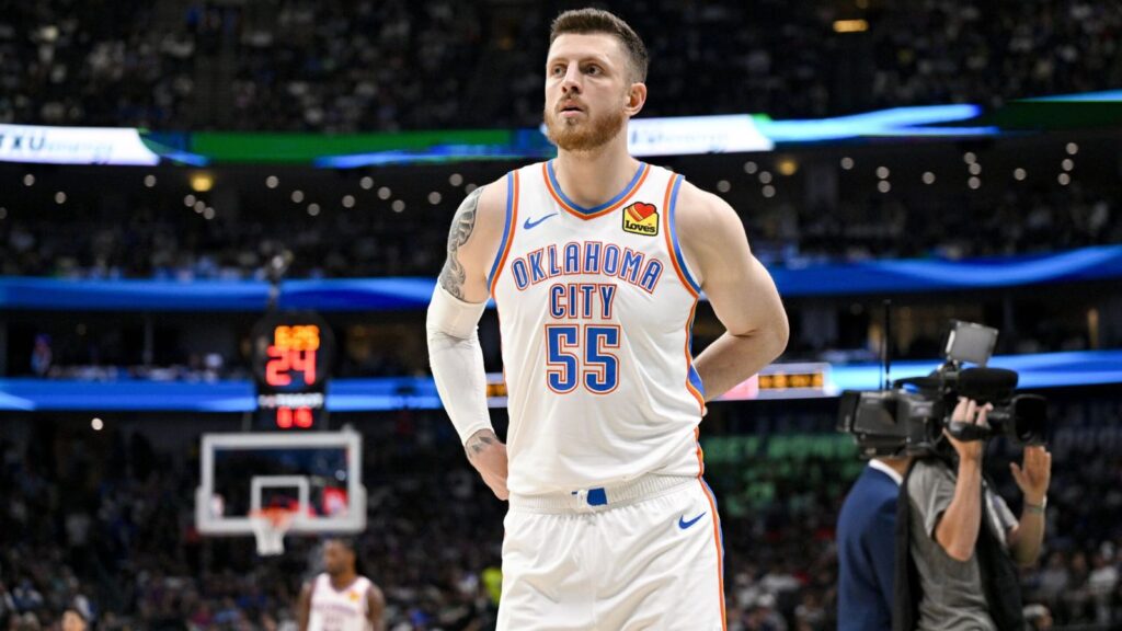 The towering OKC player looking toward the fans while adjusting his uniform