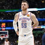 The towering OKC player looking toward the fans while adjusting his uniform
