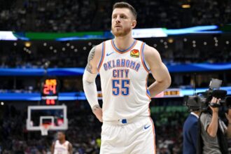 The towering OKC player looking toward the fans while adjusting his uniform