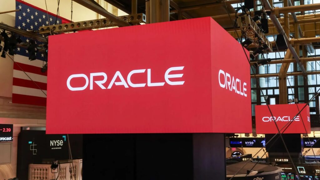 Oracle carries out mass layoffs amid Its push into artificial intelligence Several screens projecting the Oracle name with a red background and black letters