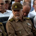The Cuban commander and politician seated with two of his companions on either side