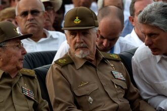 The Cuban commander and politician seated with two of his companions on either side